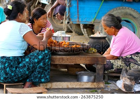 MANDALAY, MYANMAR - NOVEMBER 7:\
Local women sharing a meal in the shanty town of Mandalay, Myanmar on the 7th November, 2012.