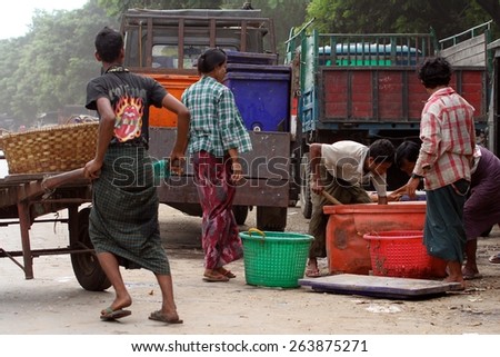 MANDALAY, MYANMAR - NOVEMBER 7:\
Local Burmese workers sorting out a catch of fish in buckets on the side of the road in the town of Mandalay, Myanmar on the 7th November, 2012.