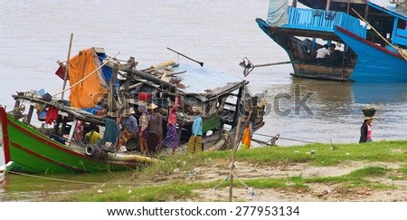 MANDALAY, MYANMAR - NOVEMBER 14:\
A rickety old boat with workers carrying stores off it on the banks of the Irrawaddy River in the town of Mandalay, Myanmar on the 14th November, 2012.