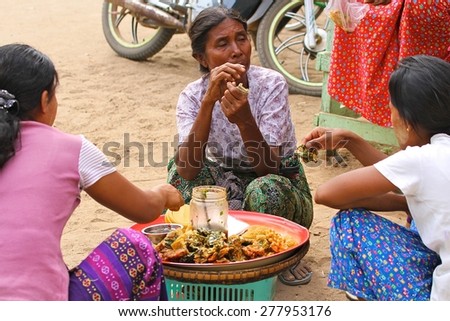 MANDALAY, MYANMAR - NOVEMBER 14:\
Three local women squatting on the ground eating at the banks of the Irrawaddy River in the town of Mandalay, Myanmar on the 14th November, 2012.