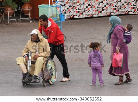 MARRAKESH, MOROCCO - OCTOBER 8:\
An elderly man being pushed in a wheelchair with his family in Jemaa el Fnaa Square, Marrakesh, Morocco on the 8th October, 2015.