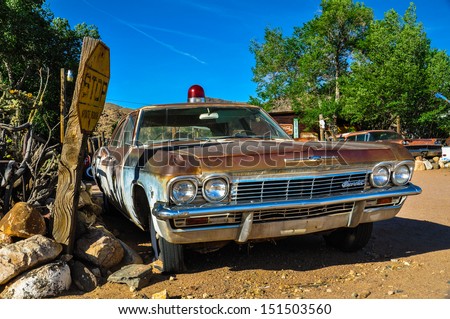 HACKBERRY, AZ - MAY 15: A vintage car with a siren left abandoned near the Hackberry General Store on May 15, 2013. Hackberry General Store is famous stop on the historic Route 66