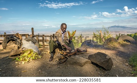NAROK COUNTY, KENYA - OCTOBER 16, 2014 : African man in a suit sells corn  at the Kamandura Mai-Mahiu Narok Road near the Great Rift Valley in Kenya, Africa.
