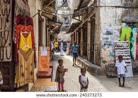 STONE TOWN, ZANZIBAR - OCTOBER 24, 2014: Local people on a typical narrow street in Stone Town. Stone Town is the old part of Zanzibar City, the capital of Zanzibar, Tanzania.