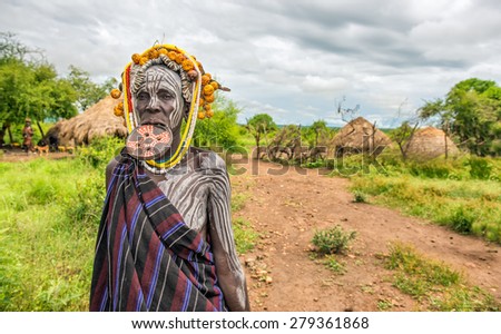 OMO VALLEY, ETHIOPIA - MAY 7, 2015 : Woman from the african tribe Mursi with big lip plate in her village.