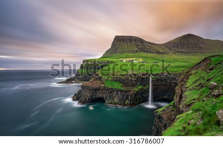 Gasadalur village and its iconic waterfall, Vagar, Faroe Islands, Denmark. Long exposure.