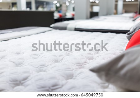 Closeup of many mattresses on display in store