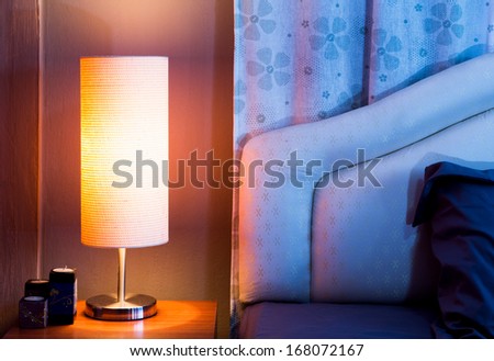 Lamp On A Night Table Next To A Bed