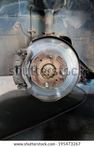 Front disk brake on car showing the front rotor and caliper