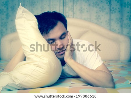Asian man in bed suffering insomnia and sleep disorder thinking about his problem