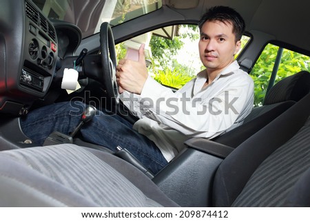 Asian Handsome Man show Thumb-up and Smile in the Car