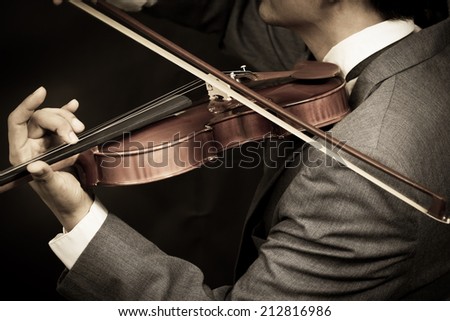 Asian male Musician plays Violin on Dark Background