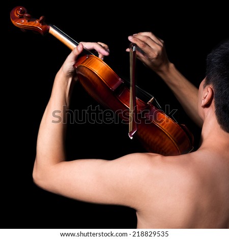 Back of Attractive Topless Handsome Asian male Musician plays Violin, isolated on black