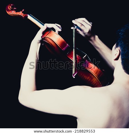 Back of Attractive Topless Handsome Asian male Musician plays Violin, isolated on black