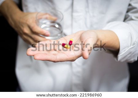 sick man / male patient hold drugs in left hand & glass of water in right hand for health concept