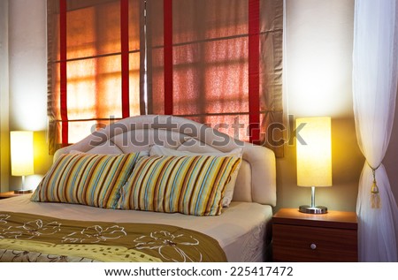 Lamp on a night table next to a bed, cozy living bedroom