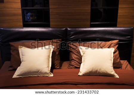 double bed with brown and white pillows in elegant bedroom