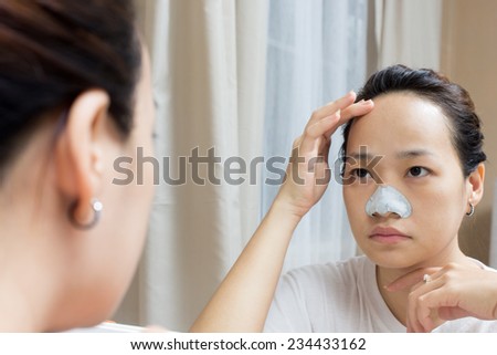 attractive asian beautiful woman caring her skin face front of mirror