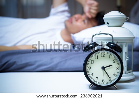 Asian man in bed suffering insomnia and sleep disorder thinking about his problem at night