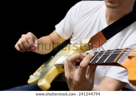 asian guitarist / musician plays electric guitar, isolated on black