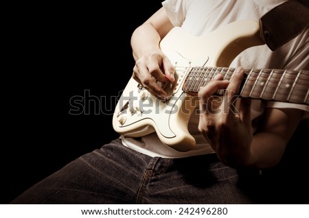 male guitarist / musician plays electric guitar / focus to right hand , isolated on black for music background concept