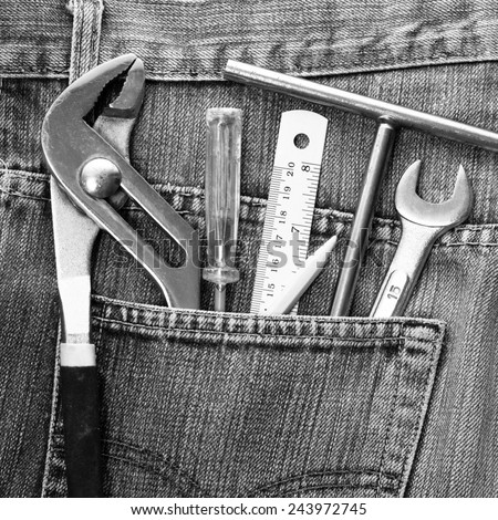 work tools in jeans pocket , black and white processed