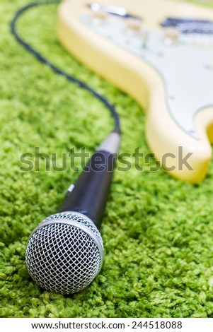 electric guitar & dynamic microphone on green / green music concept