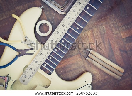 yellow electric guitar on wood in repair & guitar maker luthier workshop , fixing guitar & music instrument repairing concept