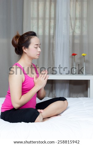Young beautiful asian woman in prayer position yoga in bedroom