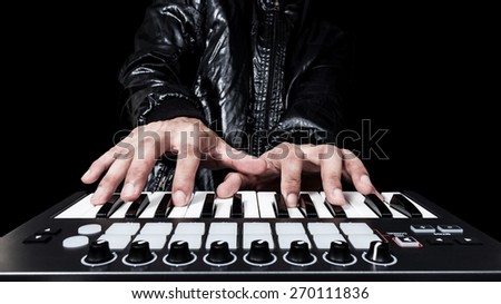 professional musician or DJ hand on studio keyboard synthesizer, isolated on black for dance , groove, remix, underground music background concept