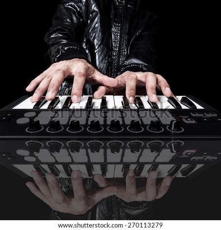 professional musician or DJ hand on studio keyboard synthesizer & reflection, isolated on black for dance , groove, remix, underground music background concept