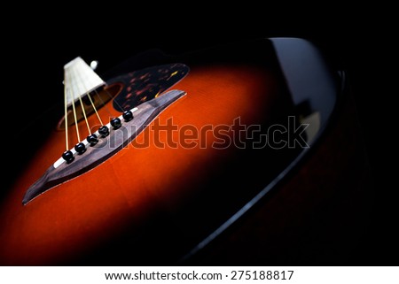 sunburst color acoustic guitar , shallow dept of field & focus to bridge pin / isolated on black  for music background