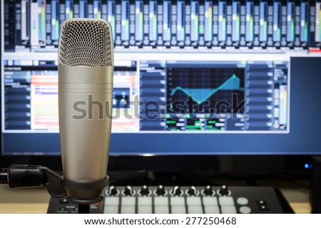 studio condenser microphone, midi synthesizer knob & digital mixer on screen monitor for computer music or broadcasting concept background