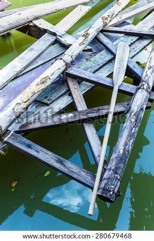 old wooden paddle on pontoon floating on water