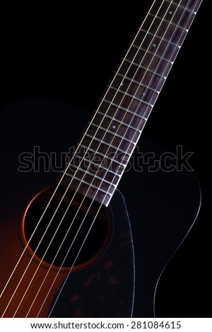 low key vertical image showing part of sunburst acoustic guitar & beautiful rim light of six strings, frets and body shape , isolated on black + copy space for music concept background