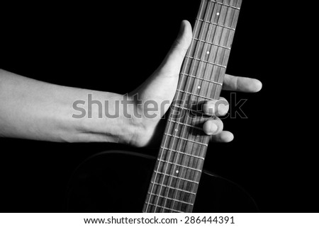 guitarist left hand hold guitar , black and white processed & isolated on black , ( hand sign mean love ) concept = love to play music