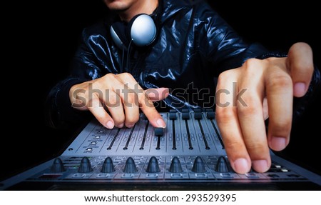 hand of asian handsome DJ, producer working on digital studio mixer for night club, radio , TV broadcasting background