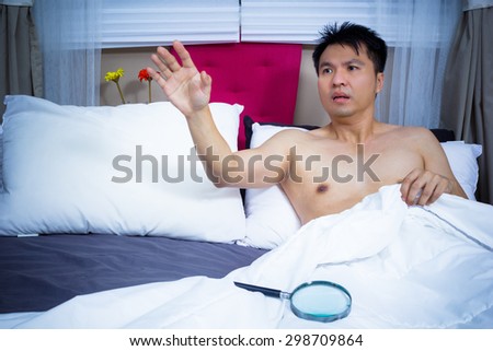unhappy man with sex problem on bed. concept = too small to see without magnifier