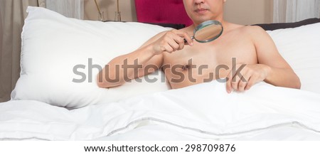 unhappy man with sex problem on bed. concept = too small to see without magnifier