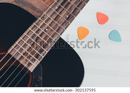 acoustic guitar and colorful picks on blank music sheet for music background, old color film processed