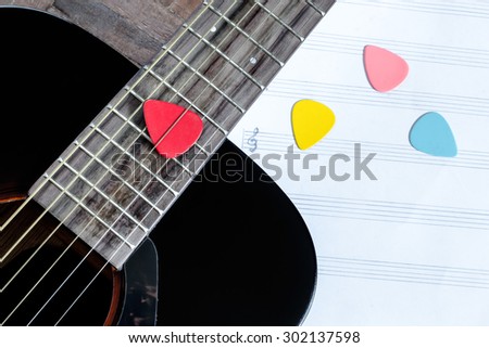 acoustic guitar and colorful picks on blank music sheet for music background
