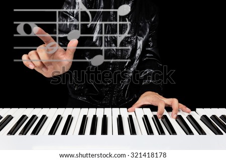 hands of male artist / pianist / musician playing piano and composing music in the imagination isolated on black for composer or music production technology concept