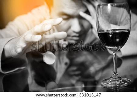 Drunk and lonely asian man, wine glass & whiskey bottle / focus to glass