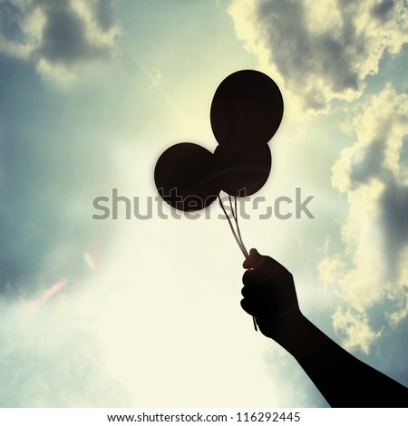 balloon in hand under sun