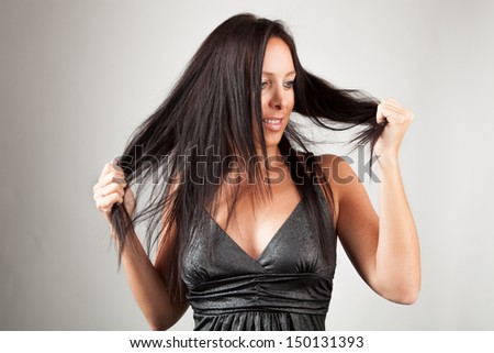 Woman looks at her hair tips and smiles