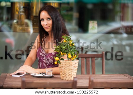 Business woman alone in a cafe with cell phone