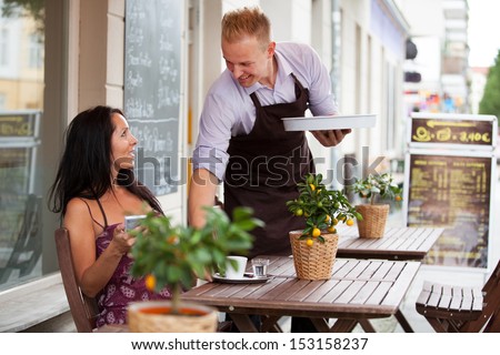 Attractive Woman In A Coffee Shop And A Smiling Waiter