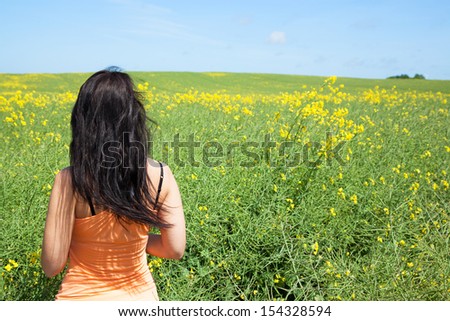 Woman from behind is looking at the flower meadow