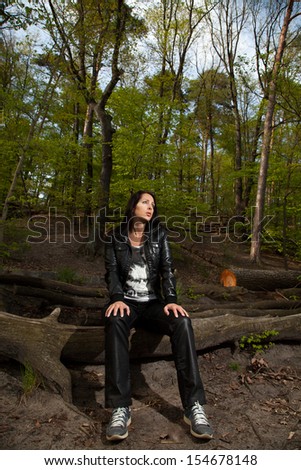 Young woman is sitting in a forest and takes a little rest