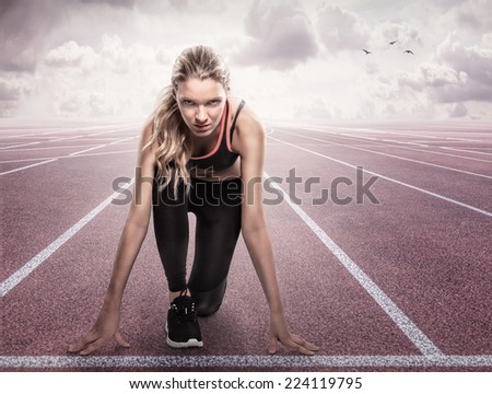 Beautiful athlete on a race track is ready to run